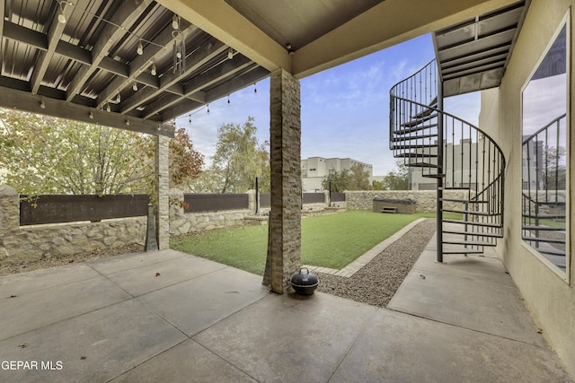 view of patio with stairs and fence