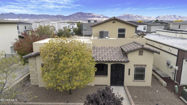 view of front facade with a tile roof, a residential view, a mountain view, and stucco siding