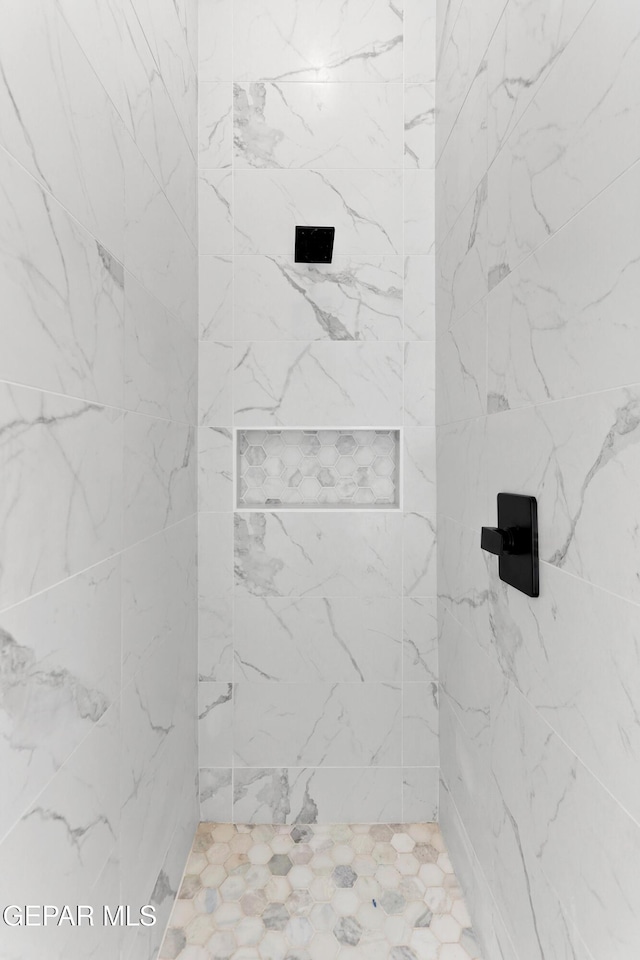 full bath featuring a marble finish shower