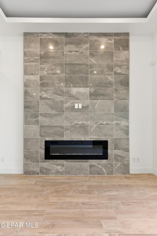 room details with wood tiled floor and a tile fireplace