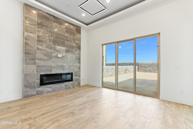 unfurnished living room with light wood-style floors, recessed lighting, a fireplace, and baseboards