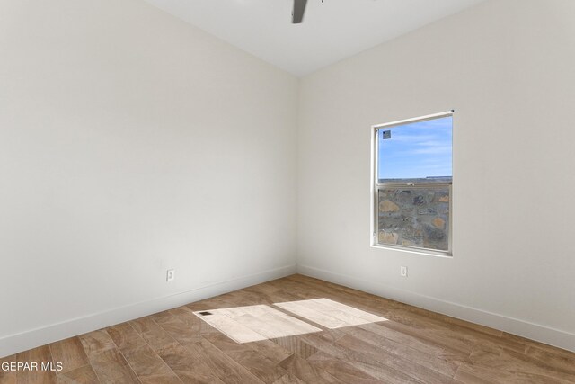 unfurnished room featuring ceiling fan, wood finished floors, and baseboards