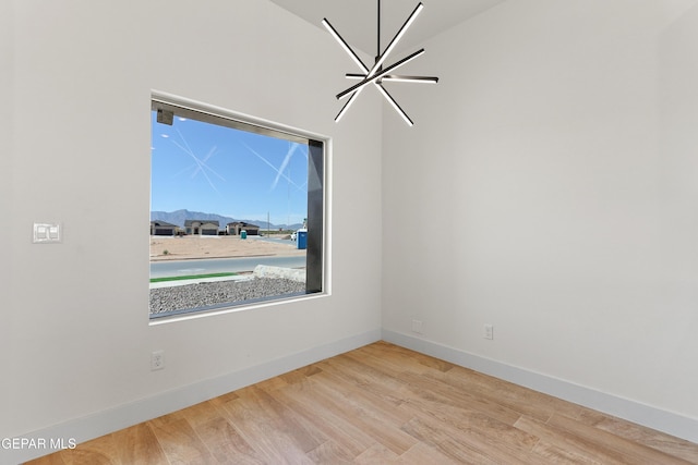 spare room featuring light wood-style flooring and baseboards