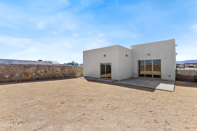 back of house featuring a patio area, fence, and stucco siding