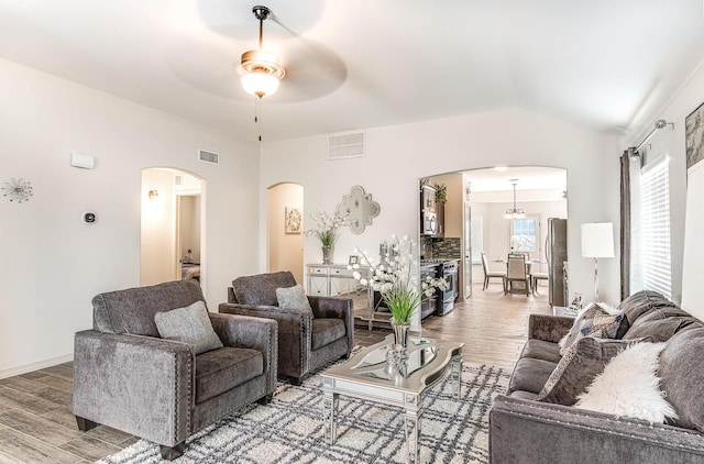 14291 Armando Silva Dr, El Paso, TX 79938 - living room with arched walkways, wood finished floors, and visible vents