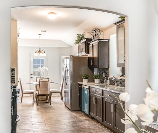 14291 Armando Silva Dr, El Paso, TX 79938 - kitchen featuring dark brown cabinetry, wood finished floors, a sink, stainless steel dishwasher, and light stone countertops