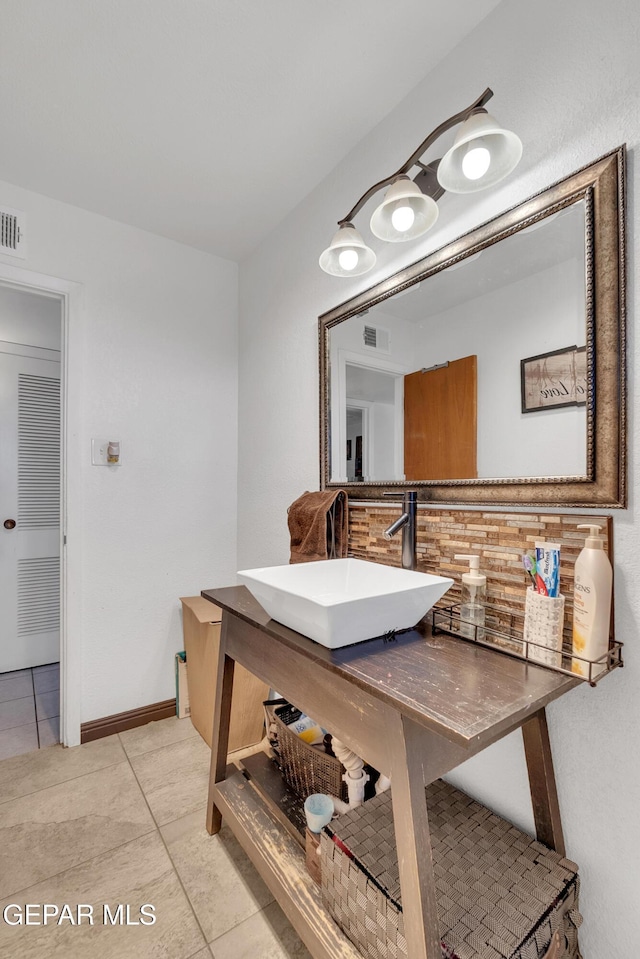 bathroom with baseboards, visible vents, a sink, and tile patterned floors