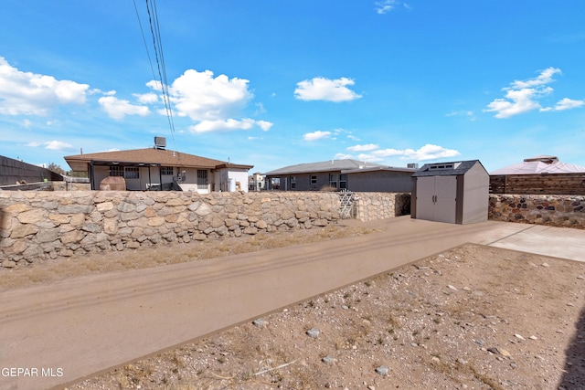 view of yard featuring an outbuilding, a shed, and fence