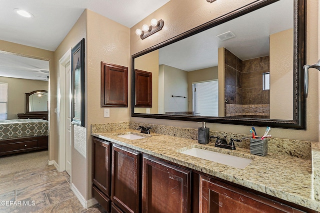 ensuite bathroom with connected bathroom, visible vents, a sink, and double vanity