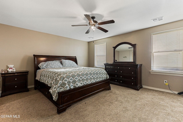 carpeted bedroom featuring ceiling fan, visible vents, and baseboards