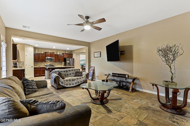 living room featuring recessed lighting, a ceiling fan, visible vents, baseboards, and stone finish floor