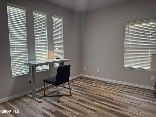 home office with baseboards and wood finished floors