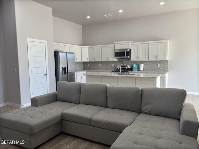 living area featuring dark wood-type flooring, recessed lighting, visible vents, and baseboards