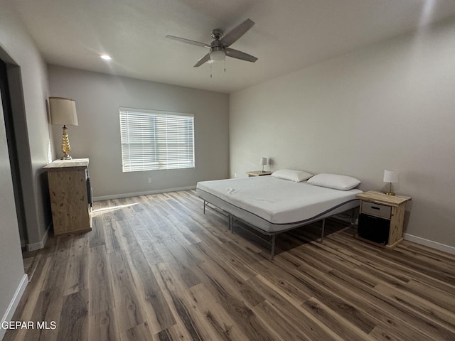 bedroom featuring baseboards, dark wood finished floors, and a ceiling fan