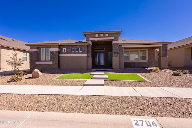 prairie-style house featuring stone siding and stucco siding