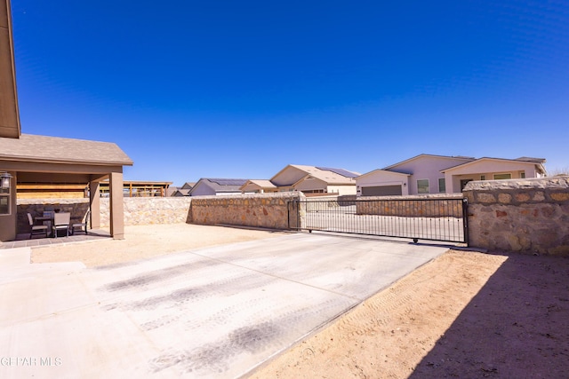 view of patio / terrace featuring a residential view, fence, and a gate