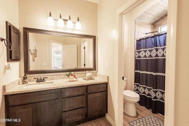 bathroom featuring vanity, a shower with shower curtain, wood finished floors, and toilet