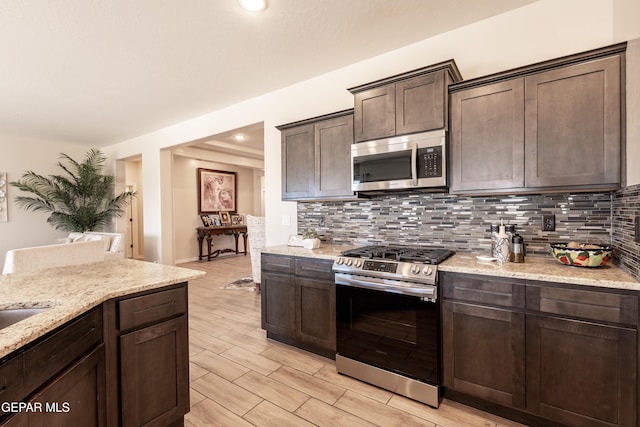 kitchen featuring stainless steel appliances, dark brown cabinets, wood tiled floor, and decorative backsplash