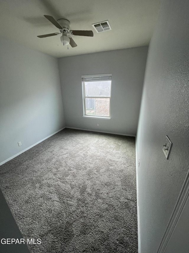 empty room featuring a ceiling fan, carpet, visible vents, and baseboards