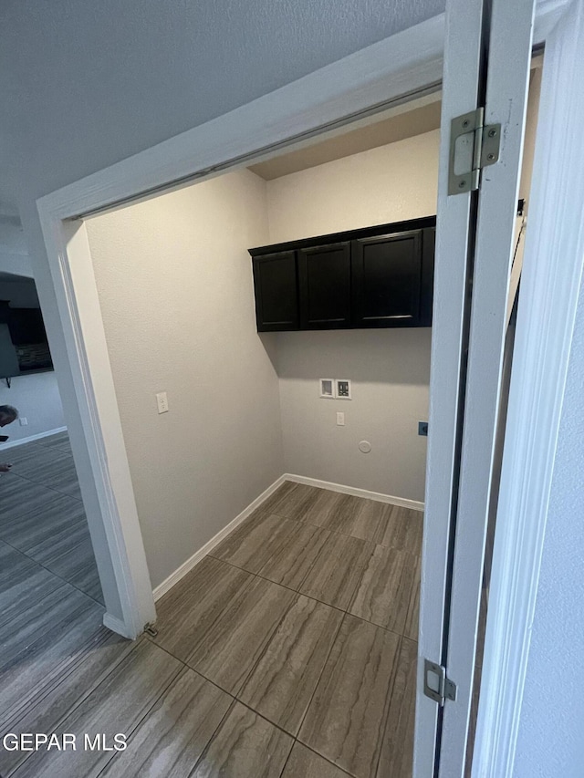 laundry room with washer hookup, wood tiled floor, cabinet space, and baseboards