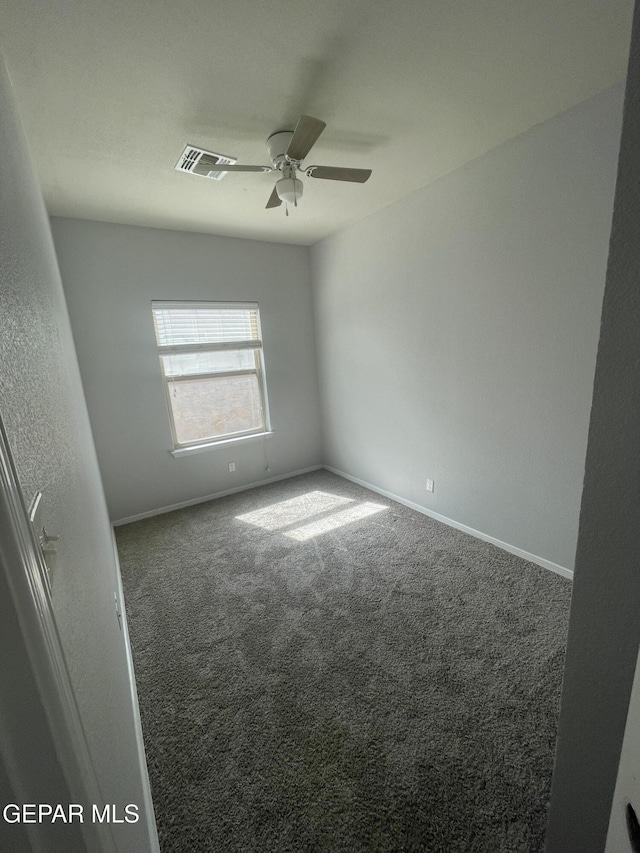 empty room featuring ceiling fan, carpet flooring, visible vents, and baseboards