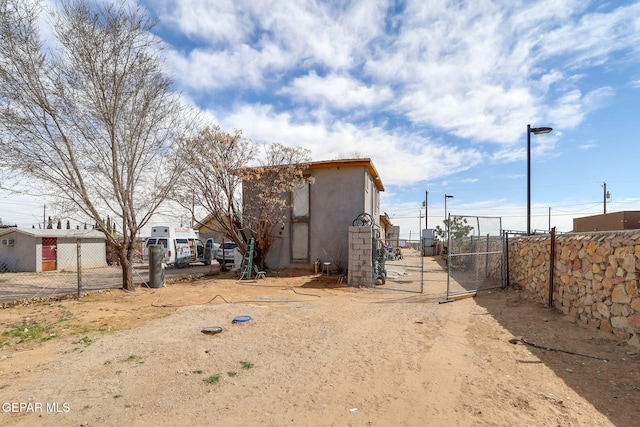 exterior space featuring fence, a gate, and stucco siding