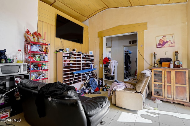 tiled living area with lofted ceiling, wood ceiling, and wood walls