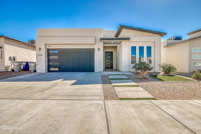 view of front of property with a garage, driveway, and stucco siding