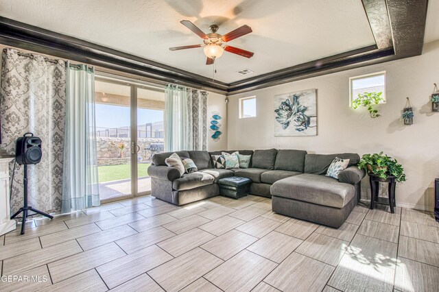 living room with a textured ceiling, visible vents, and a ceiling fan