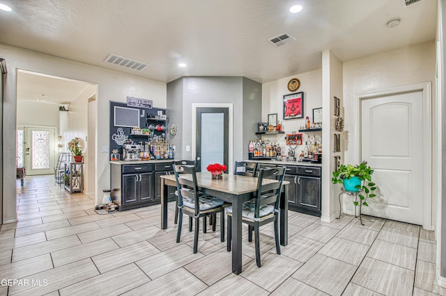 dining space with a dry bar, visible vents, and recessed lighting