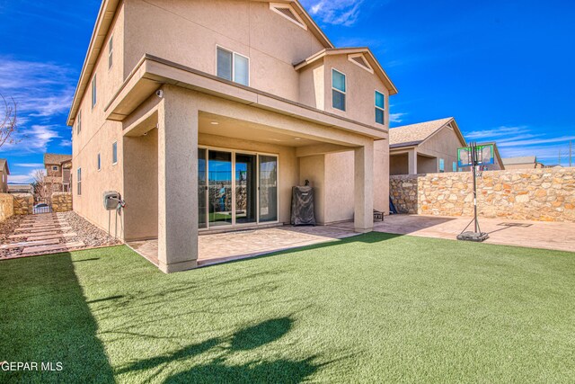 rear view of property with a yard, a patio, fence, and stucco siding