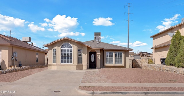 view of front of house featuring a shingled roof, fence, and stucco siding