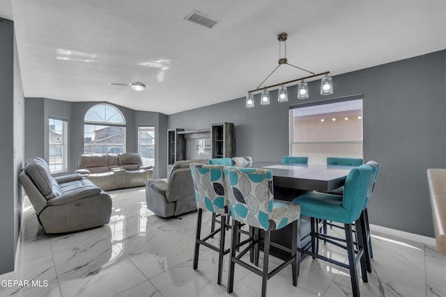 dining area with marble finish floor, visible vents, a textured ceiling, and baseboards