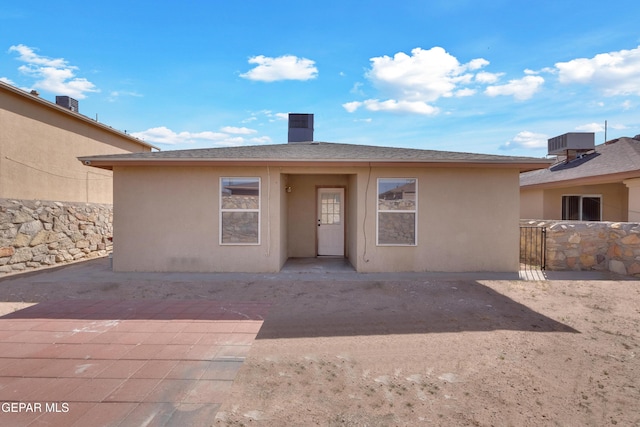 back of property featuring a gate and stucco siding