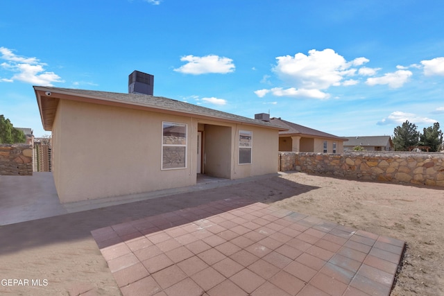 back of property with fence, a patio, and stucco siding