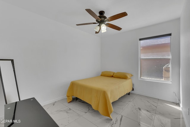 bedroom with marble finish floor, a ceiling fan, and baseboards