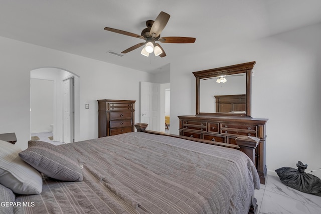 bedroom with arched walkways, ceiling fan, ensuite bathroom, visible vents, and marble finish floor