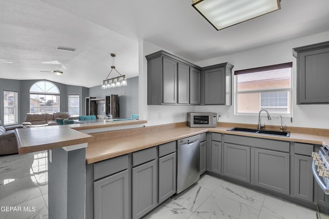 kitchen featuring gray cabinets, visible vents, stainless steel appliances, and a sink