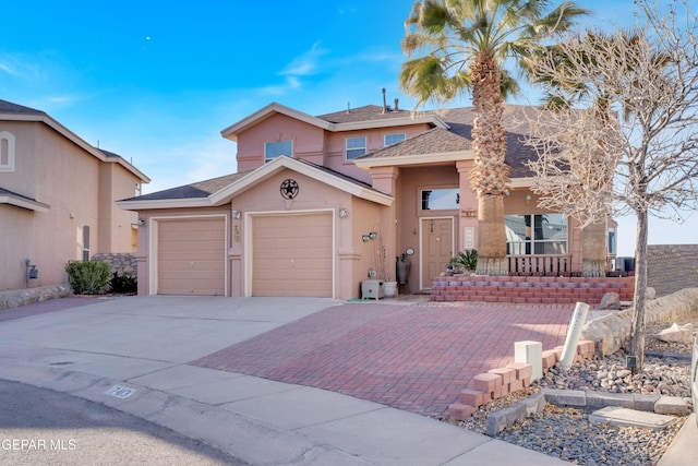 view of front of home with a shingled roof, decorative driveway, an attached garage, and stucco siding