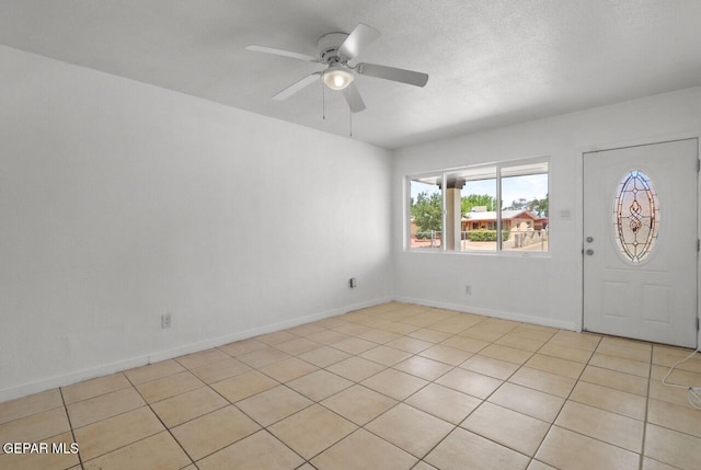 foyer featuring a ceiling fan, a textured ceiling, and baseboards