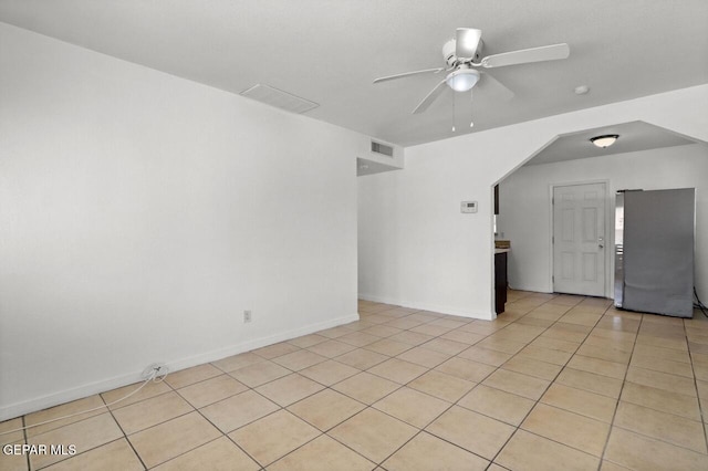 unfurnished room featuring light tile patterned floors, ceiling fan, visible vents, and baseboards