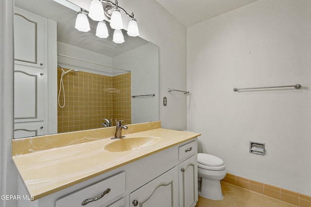 bathroom with toilet, vanity, tile patterned flooring, baseboards, and walk in shower