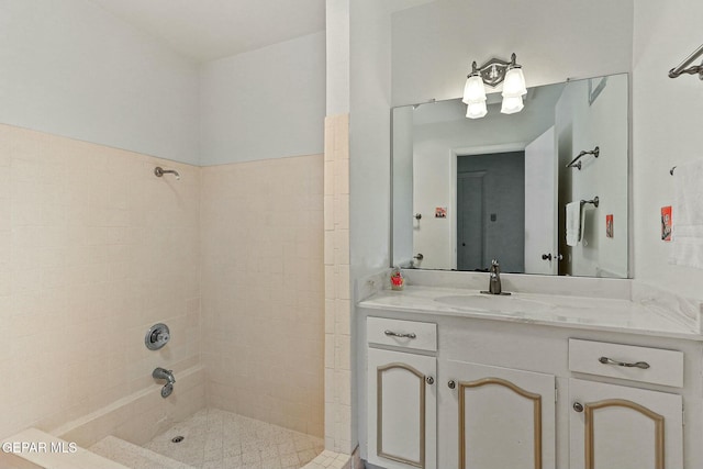 bathroom with tiled shower and vanity