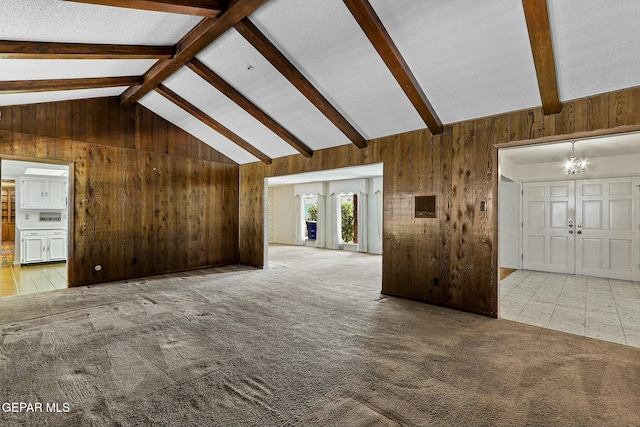 unfurnished living room featuring carpet, vaulted ceiling with beams, and wooden walls