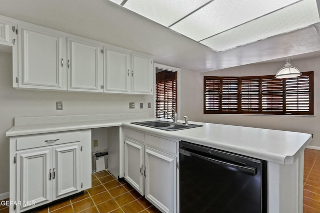 kitchen with black dishwasher, dark tile patterned floors, light countertops, a sink, and a peninsula