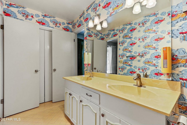 full bath featuring double vanity, a sink, and wallpapered walls