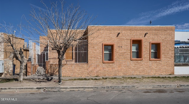 view of side of property featuring brick siding and fence