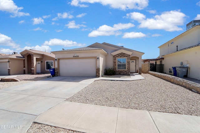 view of front of home featuring stone siding, driveway, an attached garage, and stucco siding