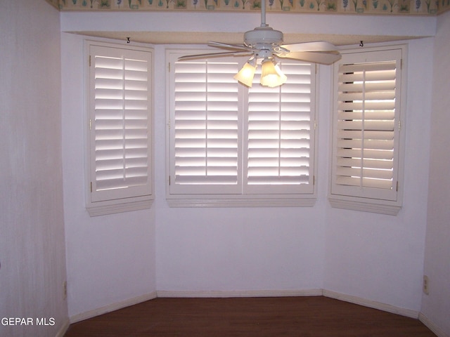 unfurnished dining area with a ceiling fan, baseboards, and wood finished floors