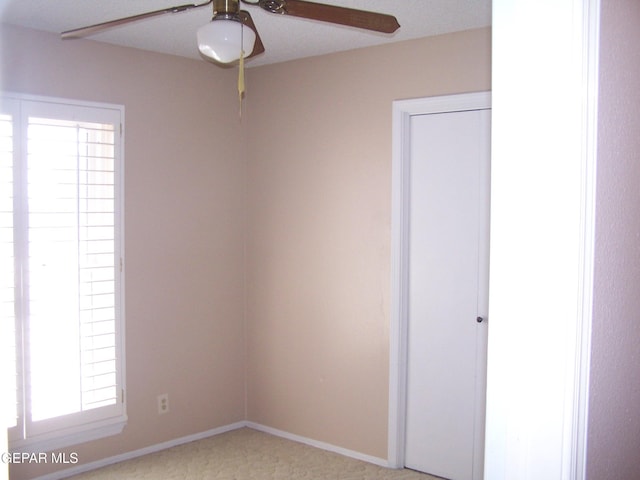 unfurnished room with baseboards and ceiling fan